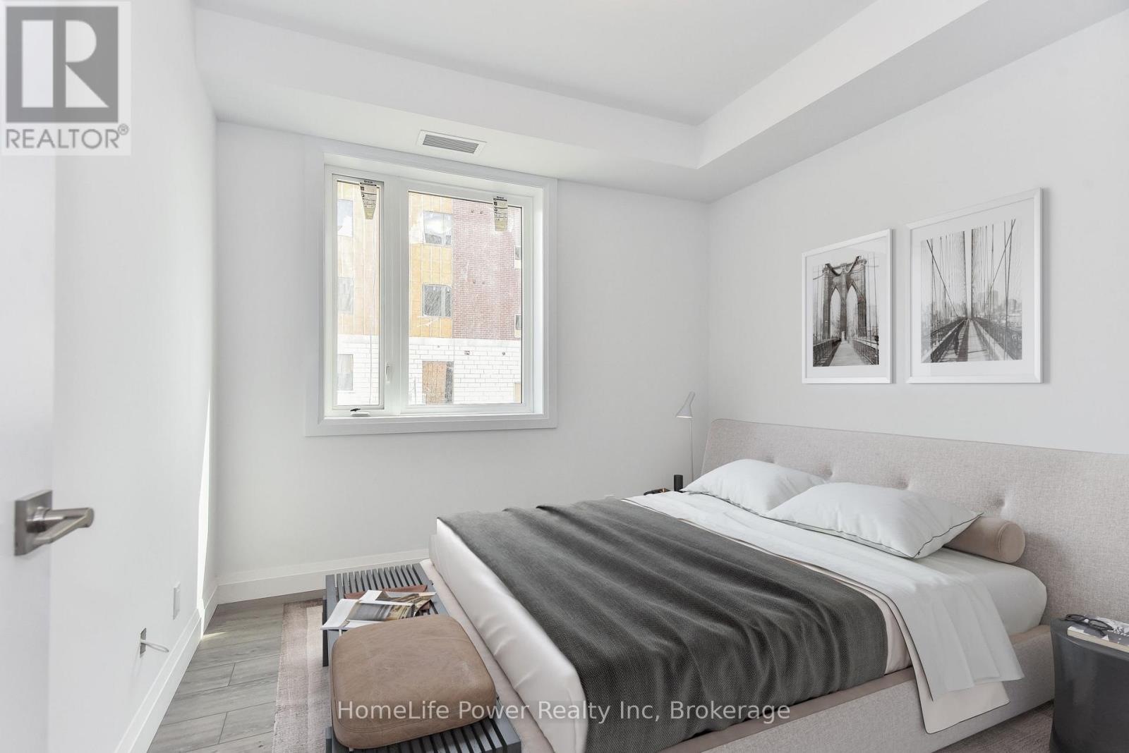A bedroom with a bed, nightstand, and two pictures on the wall.