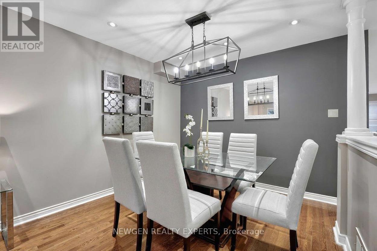 A dining room with a glass table and white chairs.