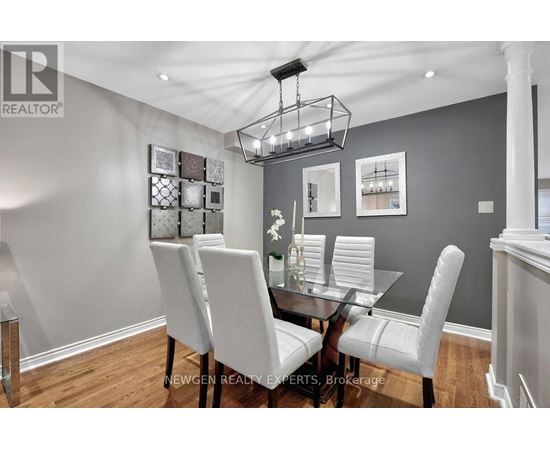 A dining room with a glass table and white chairs.
