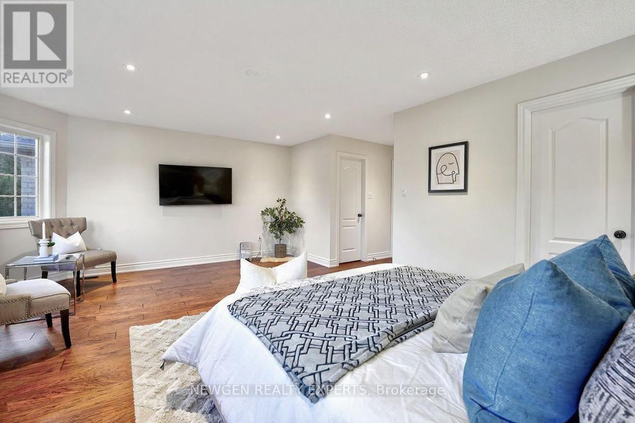 A bedroom with a large bed and a flat screen TV mounted on the wall.