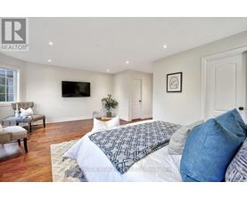 A bedroom with a large bed and a flat screen TV mounted on the wall.