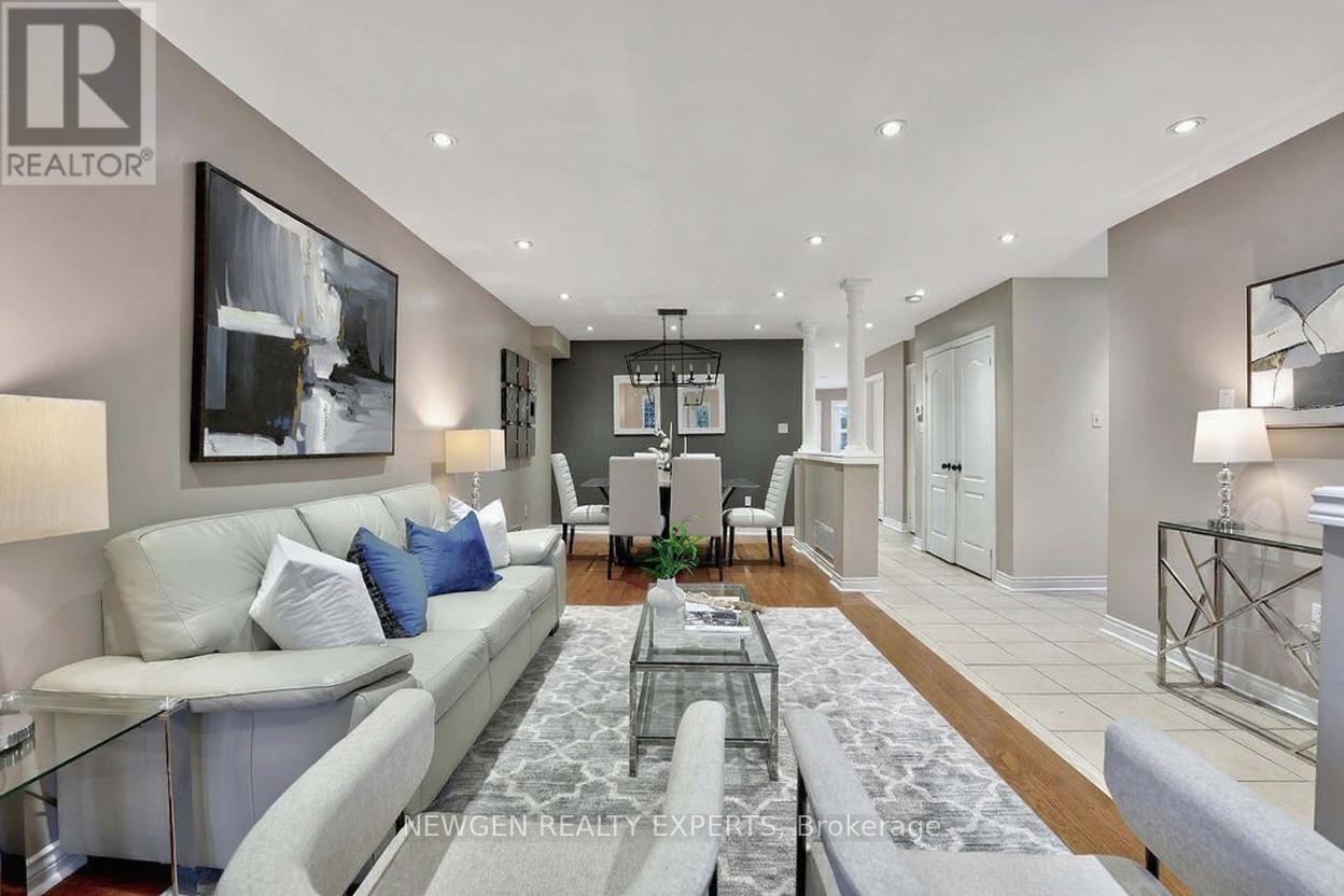 A modern living room with a glass coffee table and a grey sofa.