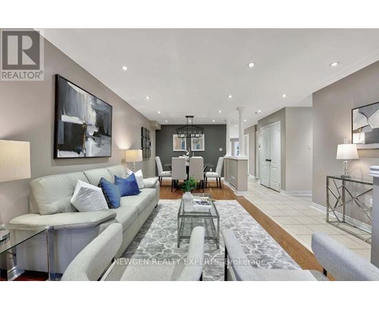 A modern living room with a glass coffee table and a grey sofa.