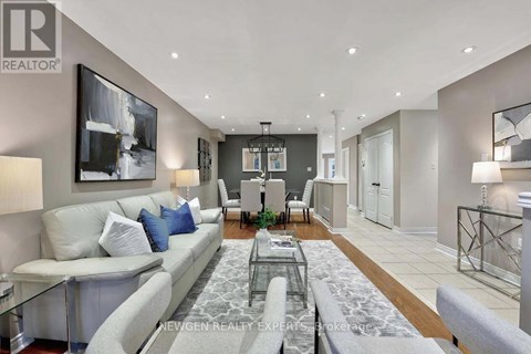 A modern living room with a glass coffee table and a grey sofa.
