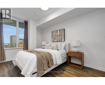 A bedroom with a large bed and a view of the city.