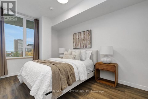 A bedroom with a large bed and a view of the city.