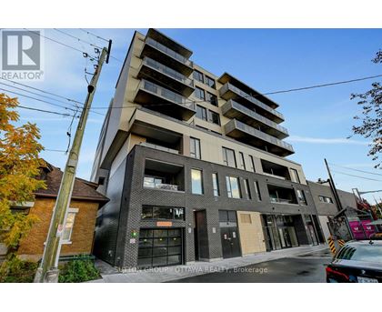 A modern apartment building with a glass facade and a brick chimney.