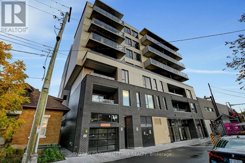 A modern apartment building with a glass facade and a brick chimney.
