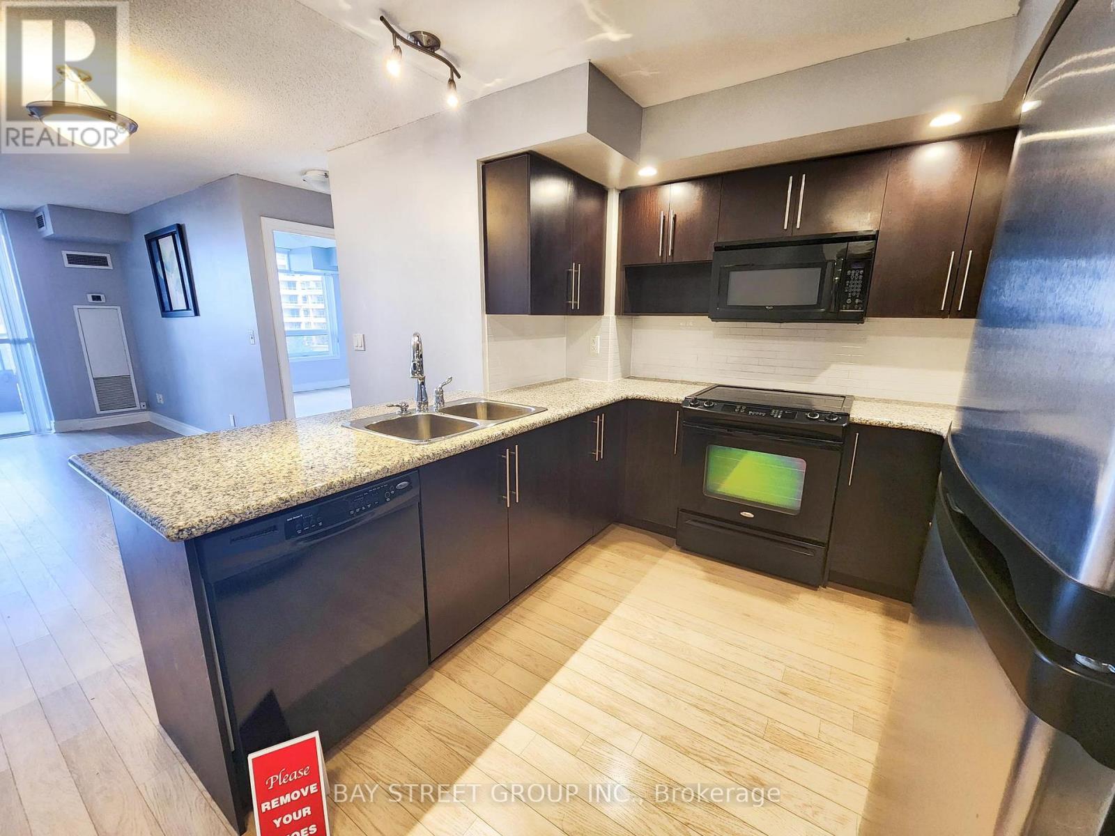 A kitchen with a granite countertop and a black oven.