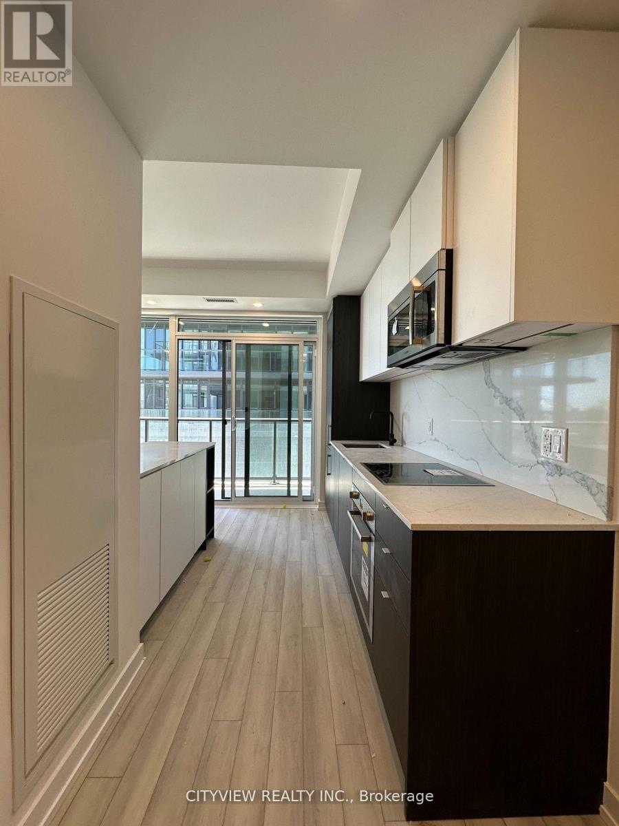A kitchen with a marble countertop and wooden flooring.