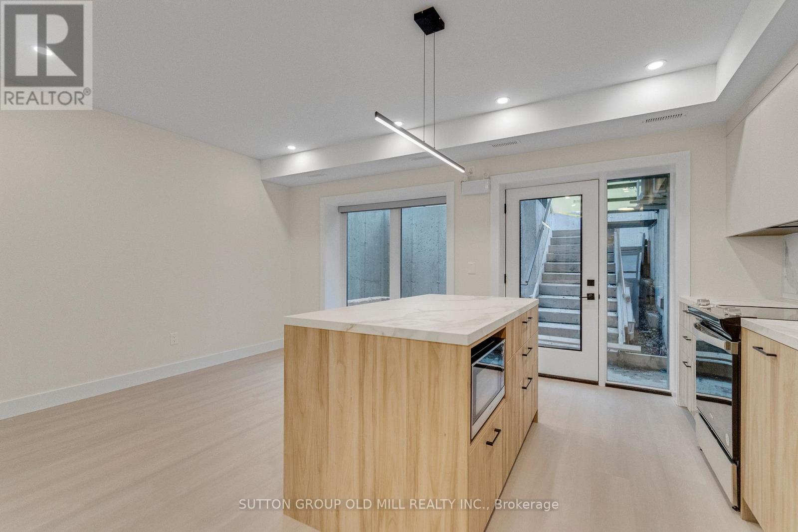 A kitchen with wooden cabinets and a large island.