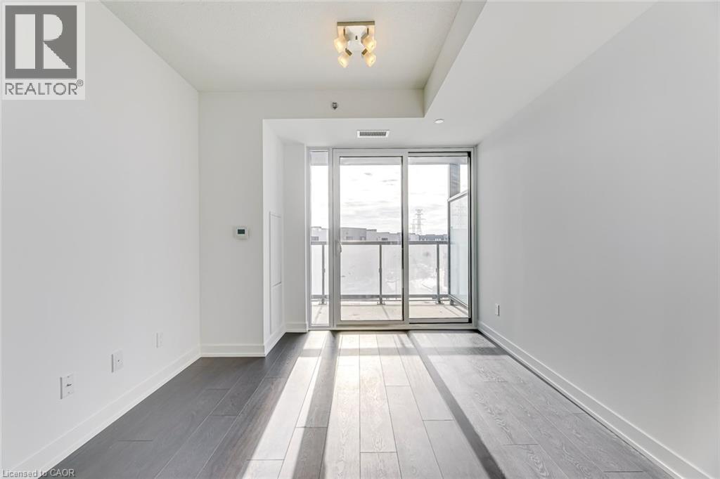A spacious room with a sliding glass door leading to a balcony.