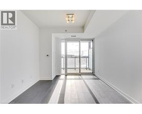 A spacious room with a sliding glass door leading to a balcony.