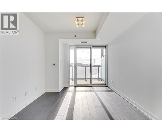 A spacious room with a sliding glass door leading to a balcony.