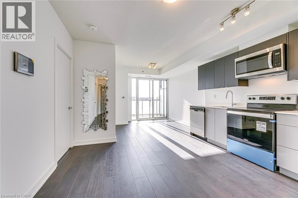 A modern kitchen with white cabinets and a wooden floor.