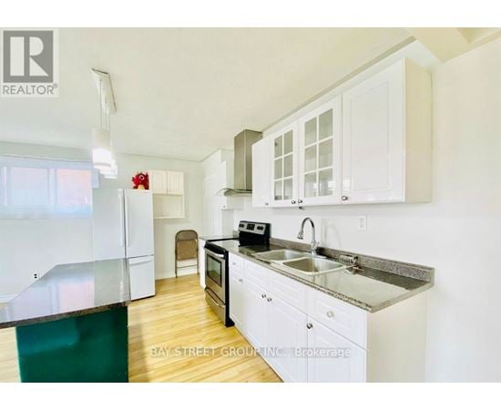 A kitchen with white cabinets and a black stove top oven.