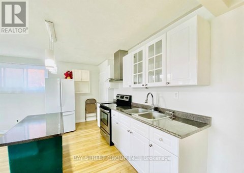 A kitchen with white cabinets and a black stove top oven.