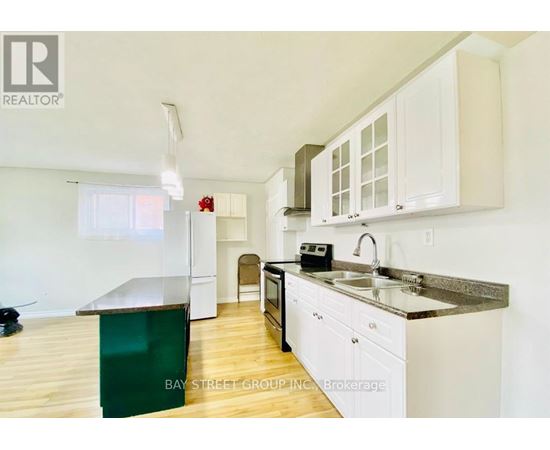 A kitchen with white cabinets and a green island.