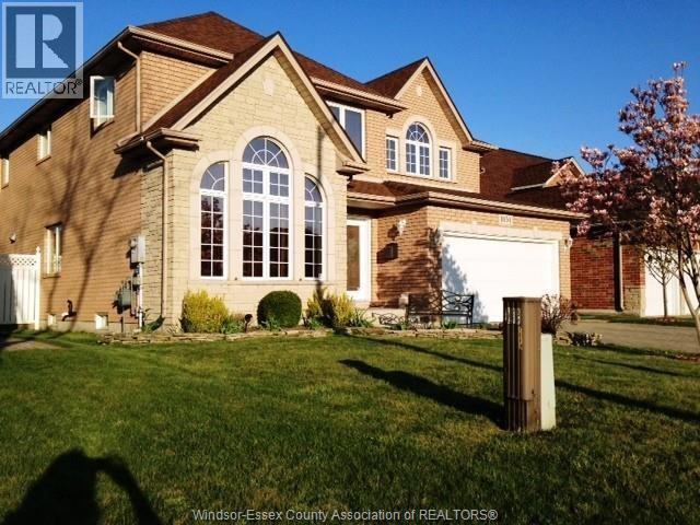 A large house with a brown roof and a white garage door.