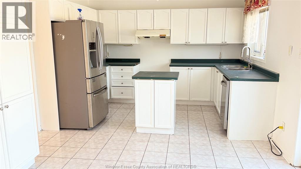 A kitchen with white cabinets and a black countertop.