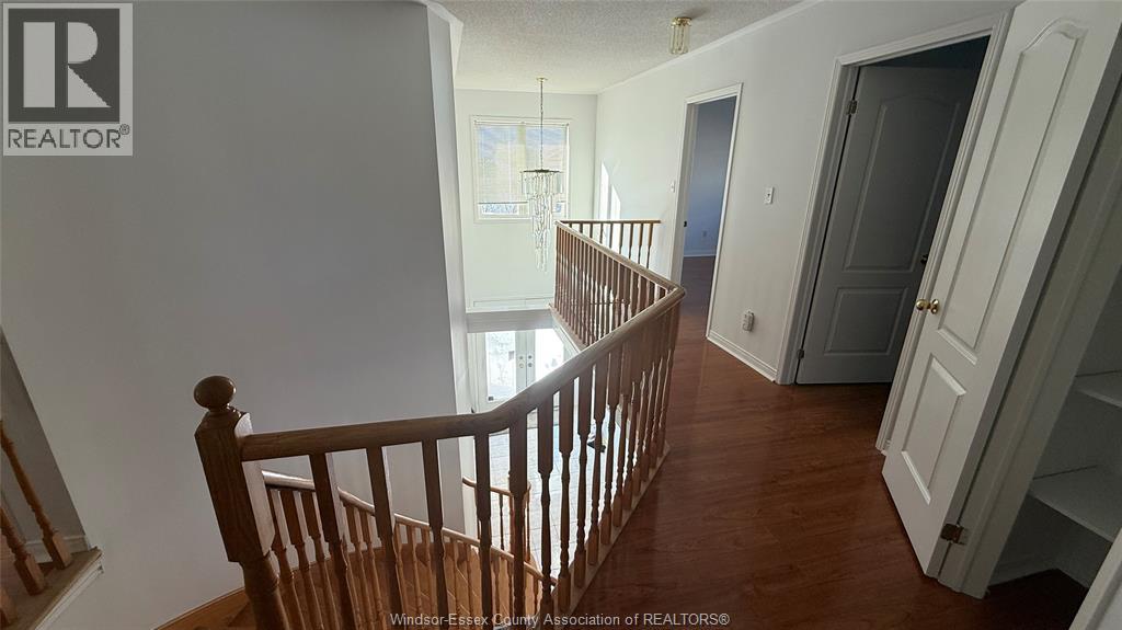 A wooden staircase leads to a brightly lit living room.