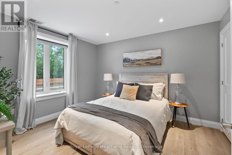 A bedroom with a large bed and a painting on the wall.