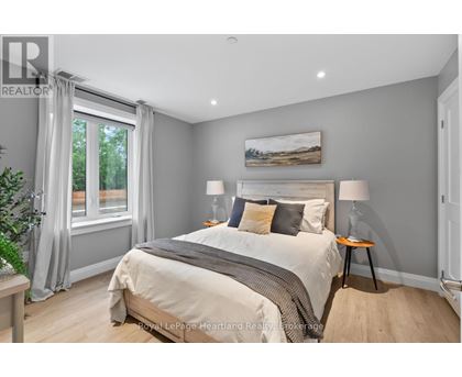 A bedroom with a large bed and a painting on the wall.