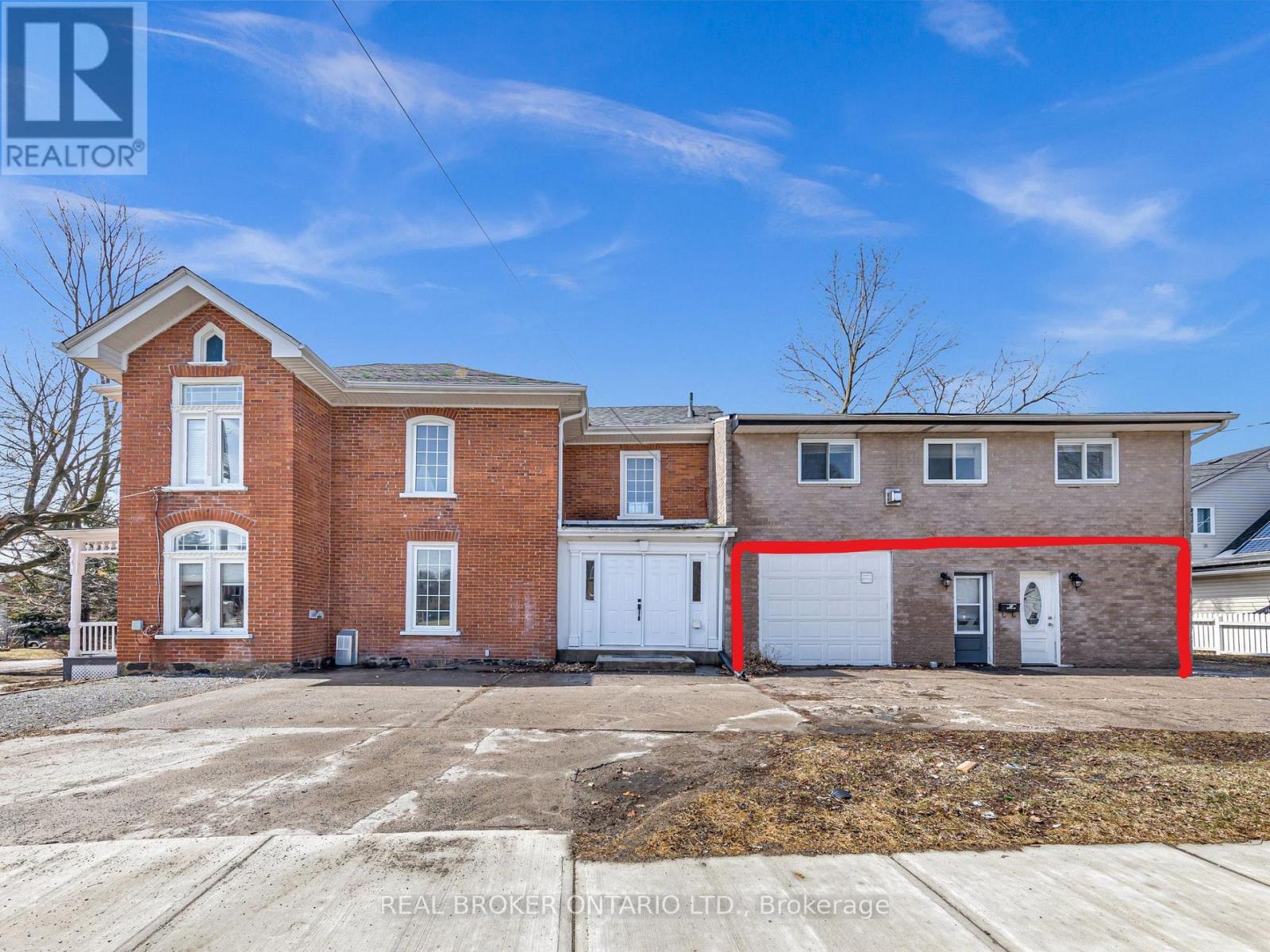A real estate broker's photo of a brick house with a red line drawn on it.