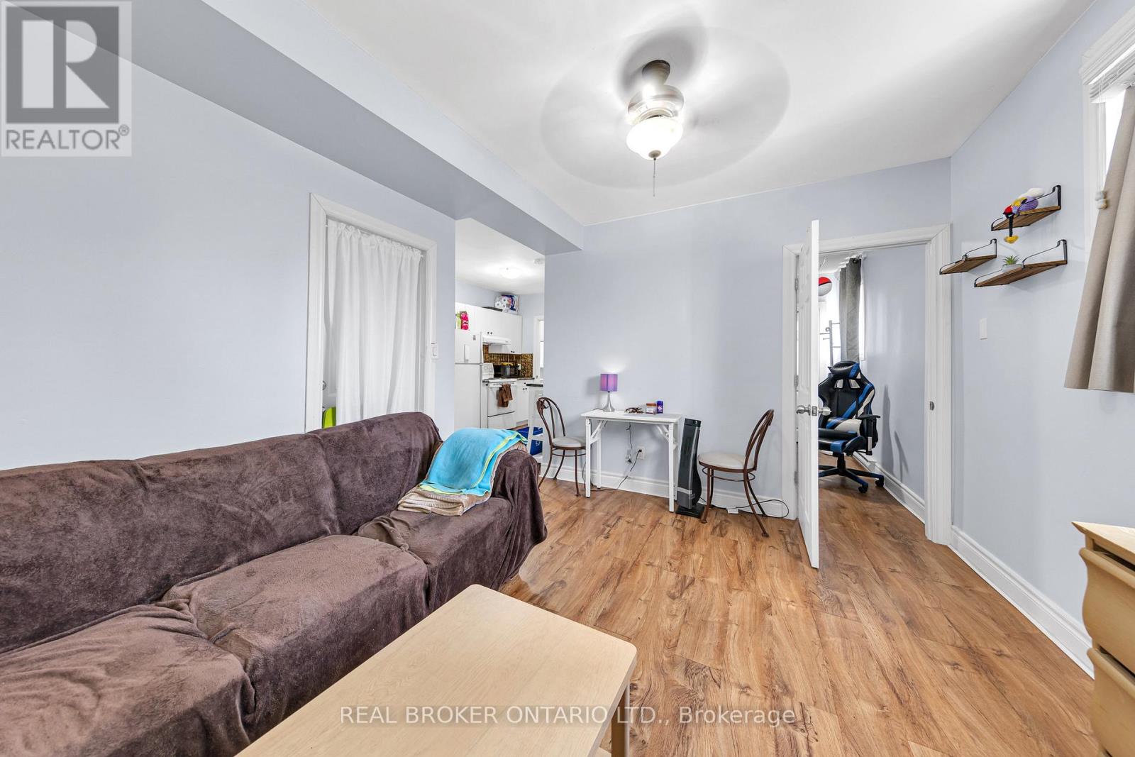 A living room with a brown couch and a white chair.