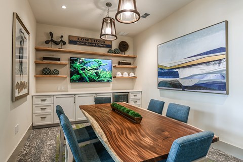 A dining room with a wooden table and blue chairs.