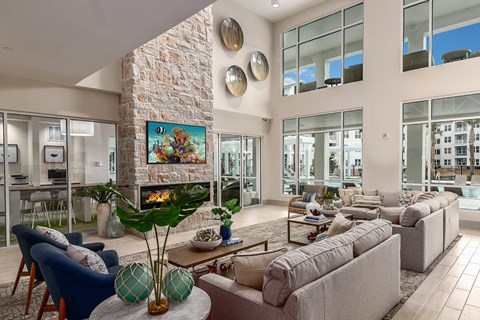 A living room with a stone fireplace and a painting above it.