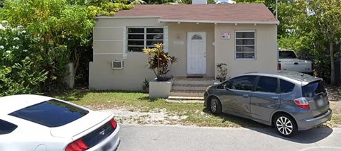 A small house with a car parked in front.