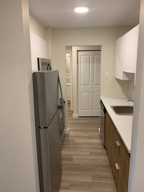 A kitchen with a refrigerator and a sink.