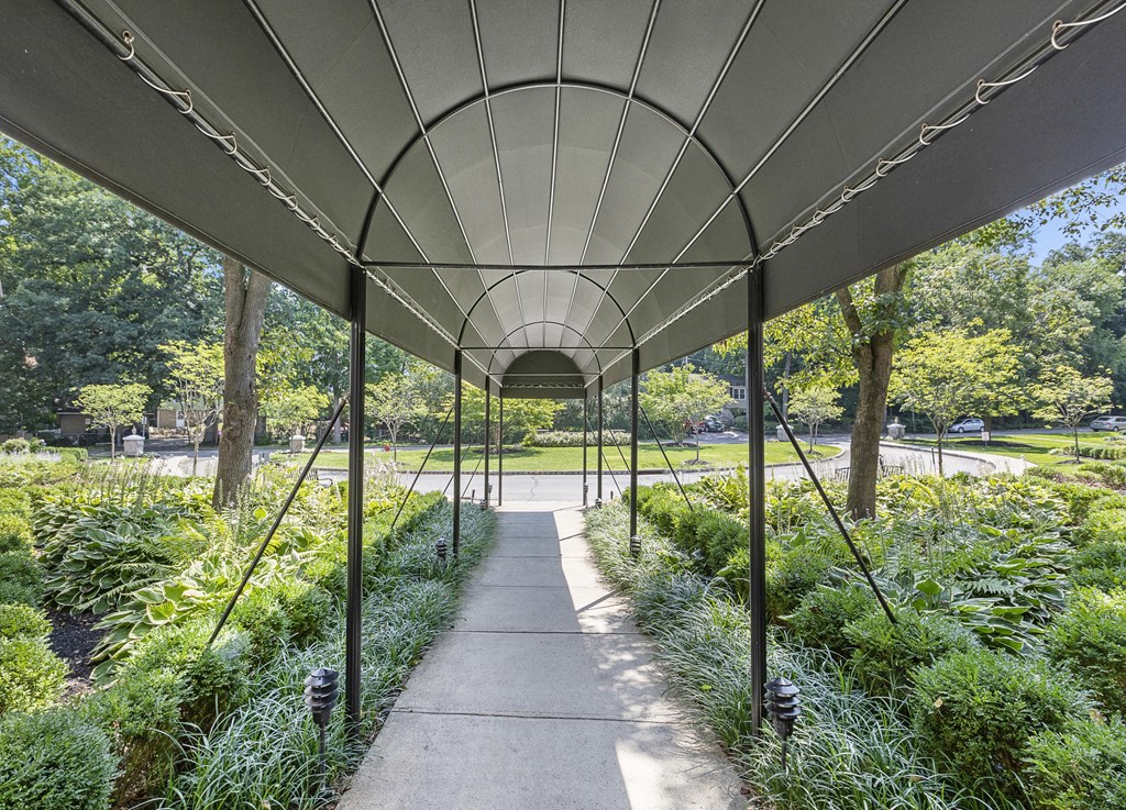 a walkway under a steel structure in a park