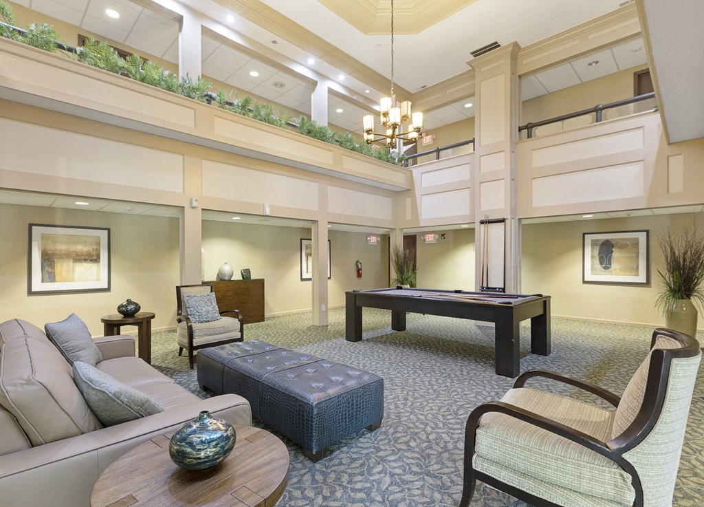 a clubhouse with a pool table and couches