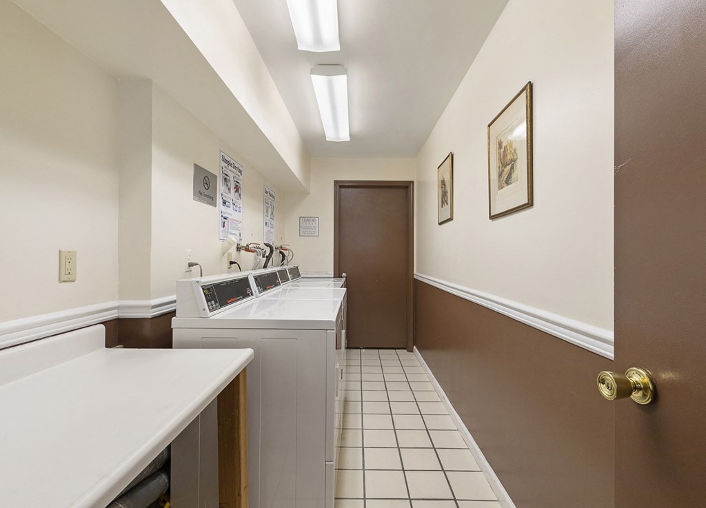 a laundry room with a washer and dryer and a door to a bathroom