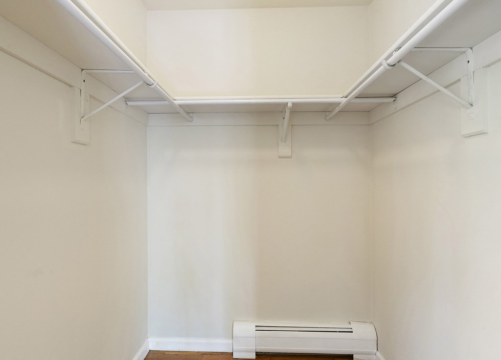 an empty room with white walls and a white bench