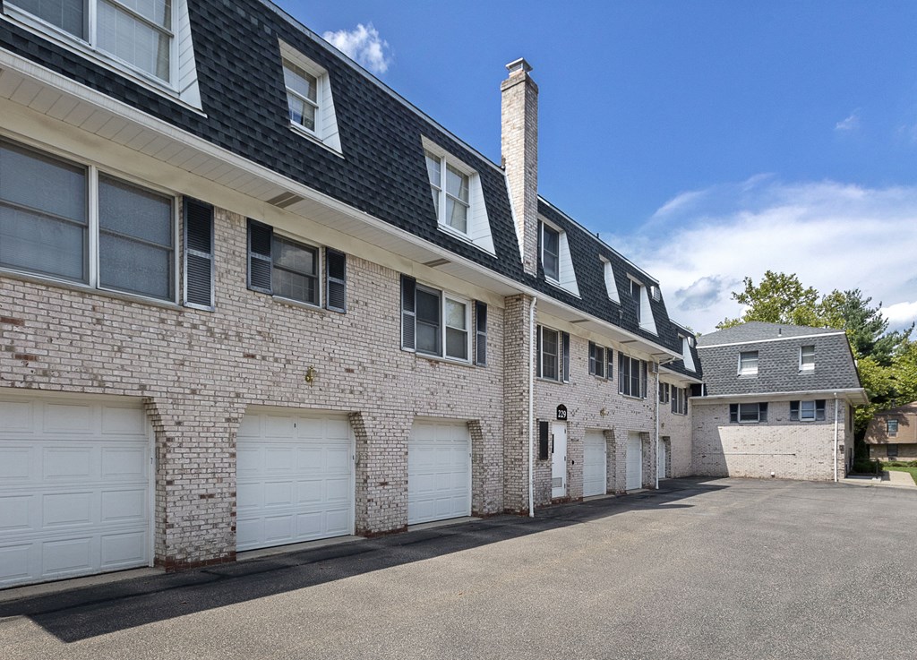 a white brick apartment building with white garage doors