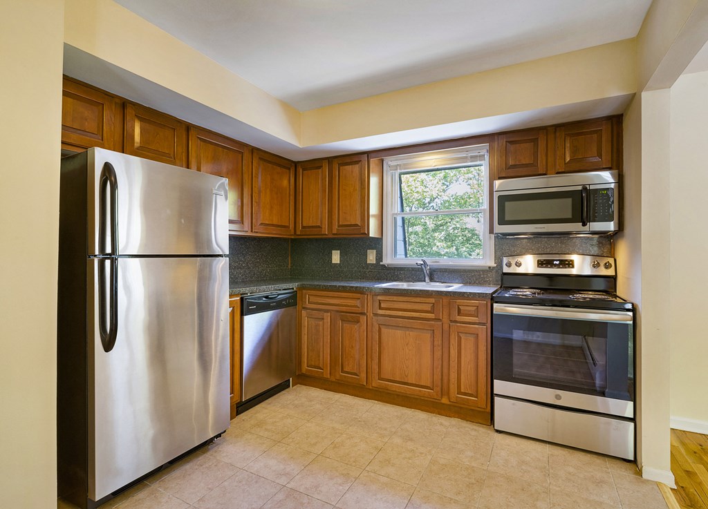 a kitchen with stainless steel appliances and wooden cabinets
