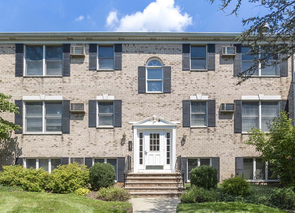 the front of a brick building with a white door