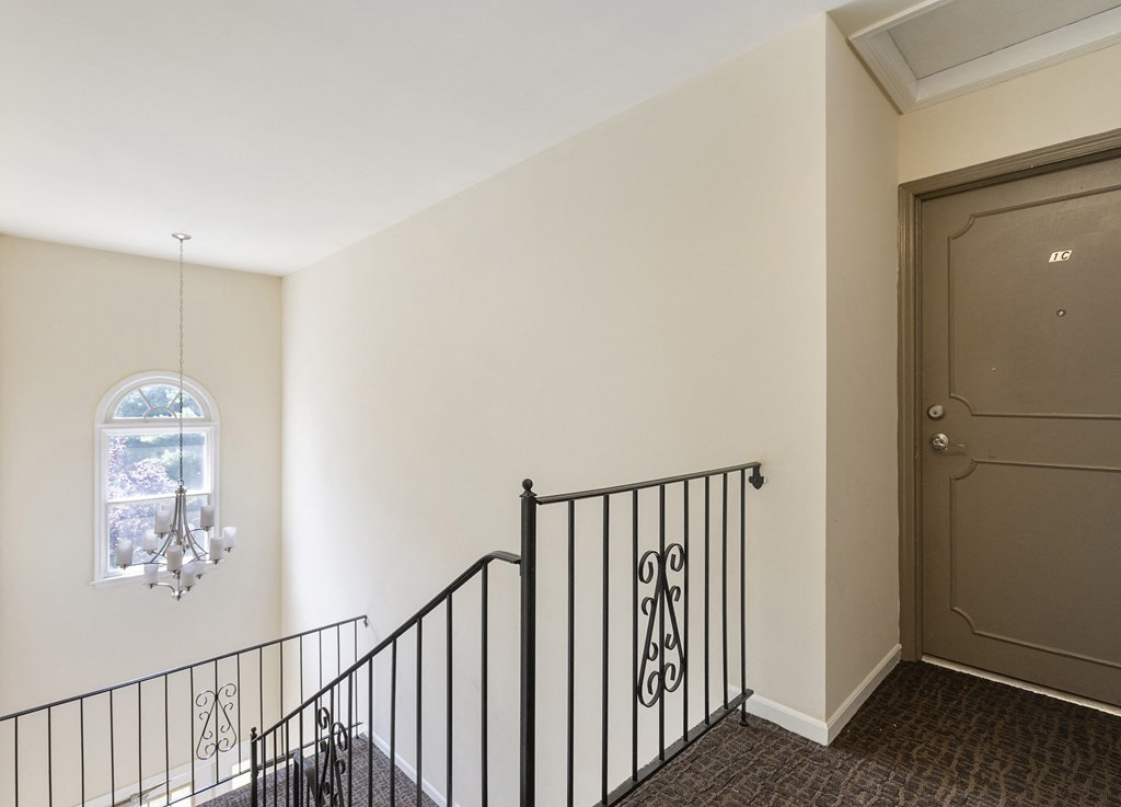 a stairwell in a home with a door and a chandelier