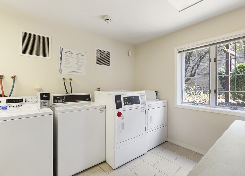 the laundry room has four washes and dryers and a window