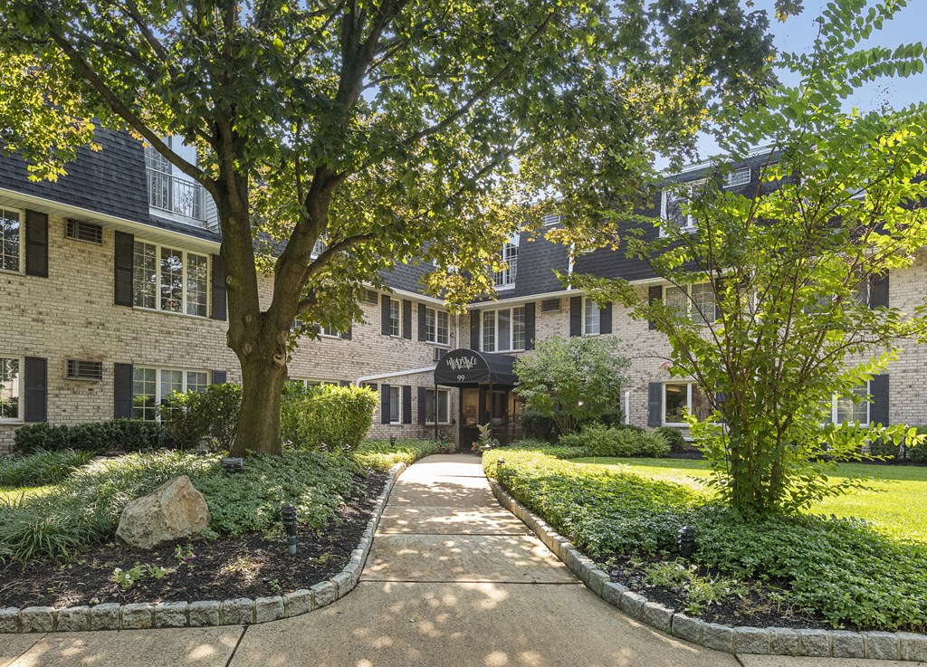a sidewalk in front of a building with trees
