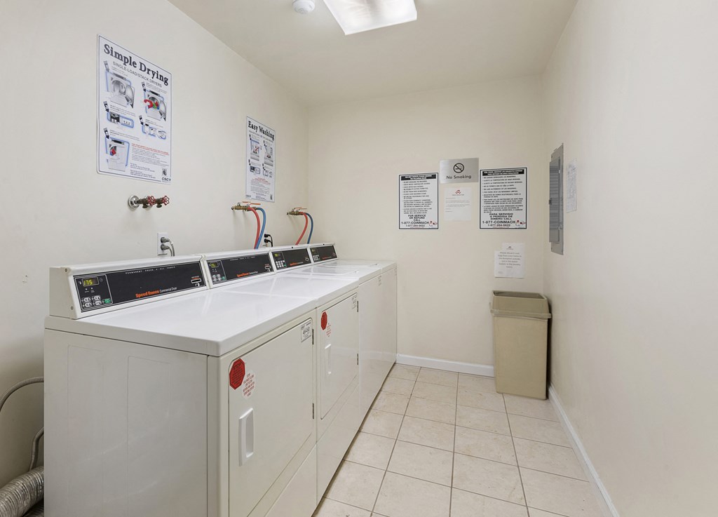 a laundry room with white cabinets and a washer and dryer