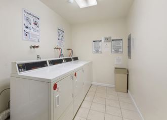 a laundry room with white cabinets and a washer and dryer