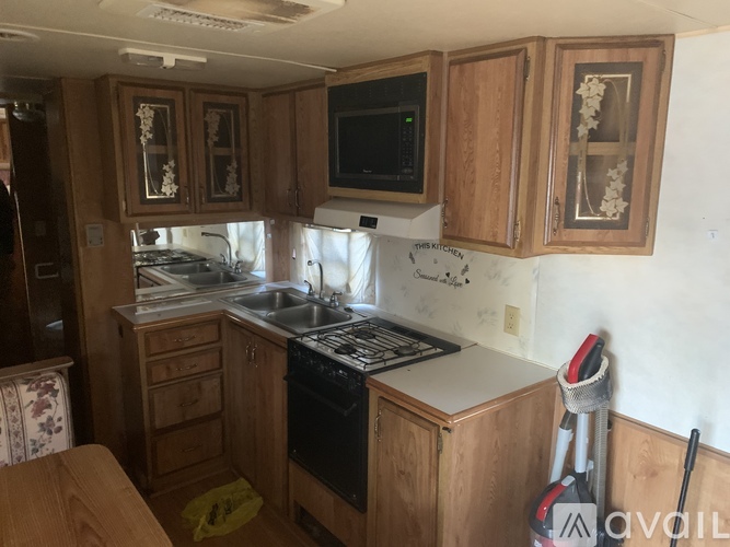 A kitchen with wooden cabinets and a black stove top oven.