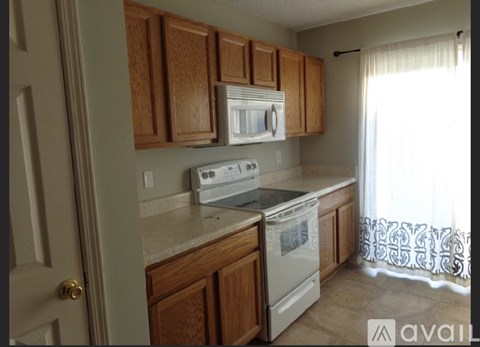 A kitchen with wooden cabinets and white appliances.