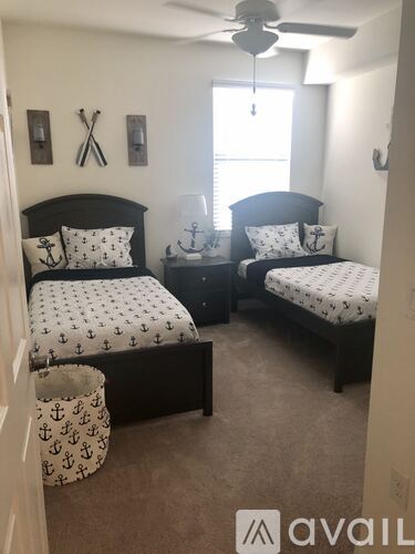 A bedroom with two beds and a ceiling fan.
