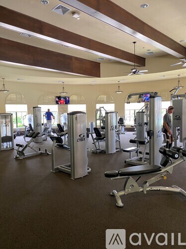 A gym with a variety of equipment including treadmills, weights, and exercise machines.