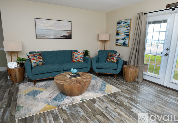 A living room with a blue couch and a wooden coffee table.